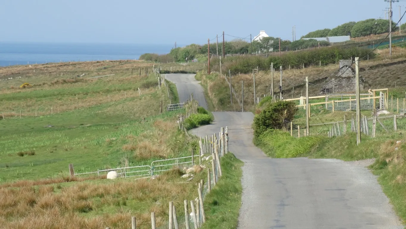 The empty lane west along the southern coast of Clare Island. I see only two vehicles over four miles of walking along this delightful undulating lane overlooking a sparkling sea dotted with little islands.