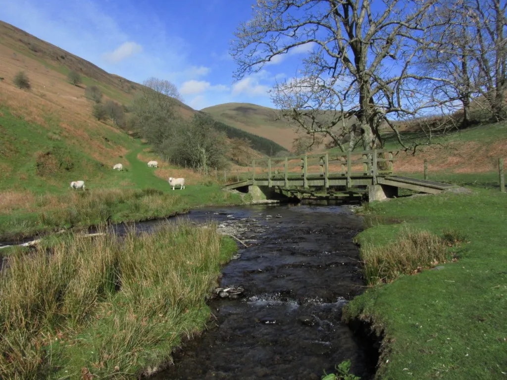 A footbridge over the stream at the foot of Harley Dingle. The valley beyond is an active firing range.