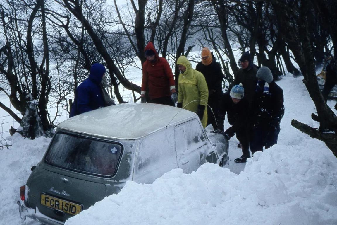 All hands to the pump. Trying to push a car up a slippery slope.
