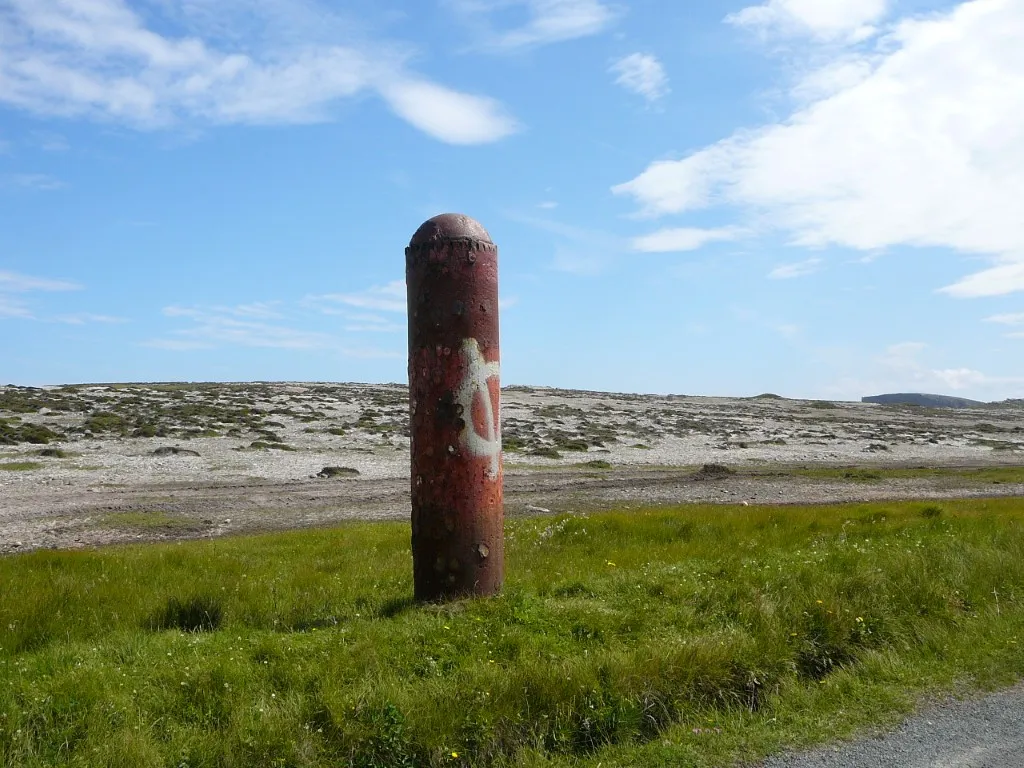 Now who left this here! A rusting torpedo upended by the island road.